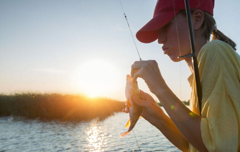 ragazza pesca il persico reale